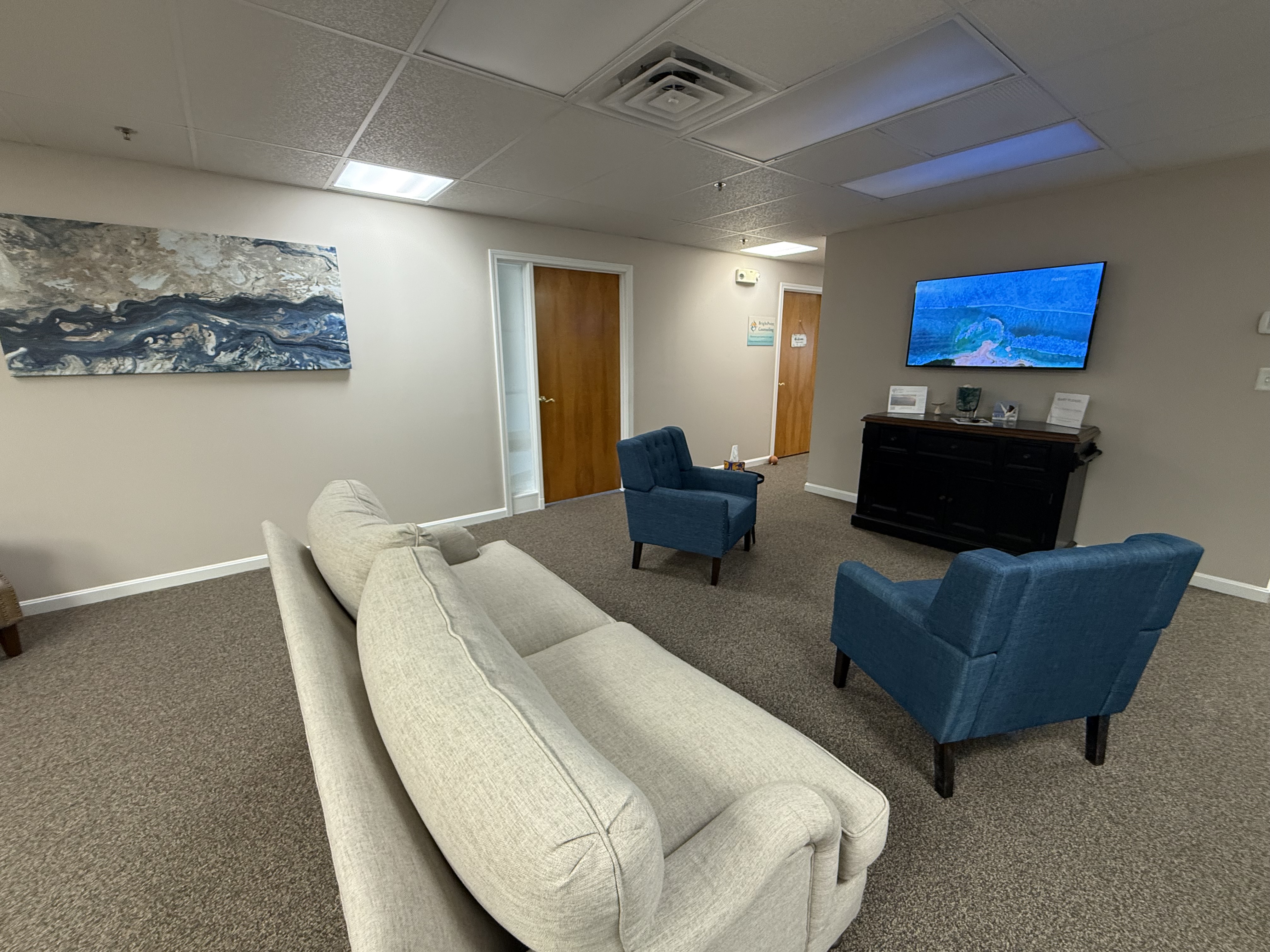The Psychedelics of Louisville waiting area — comfortable sofa, blue chairs, and abstract art in a calm welcoming space